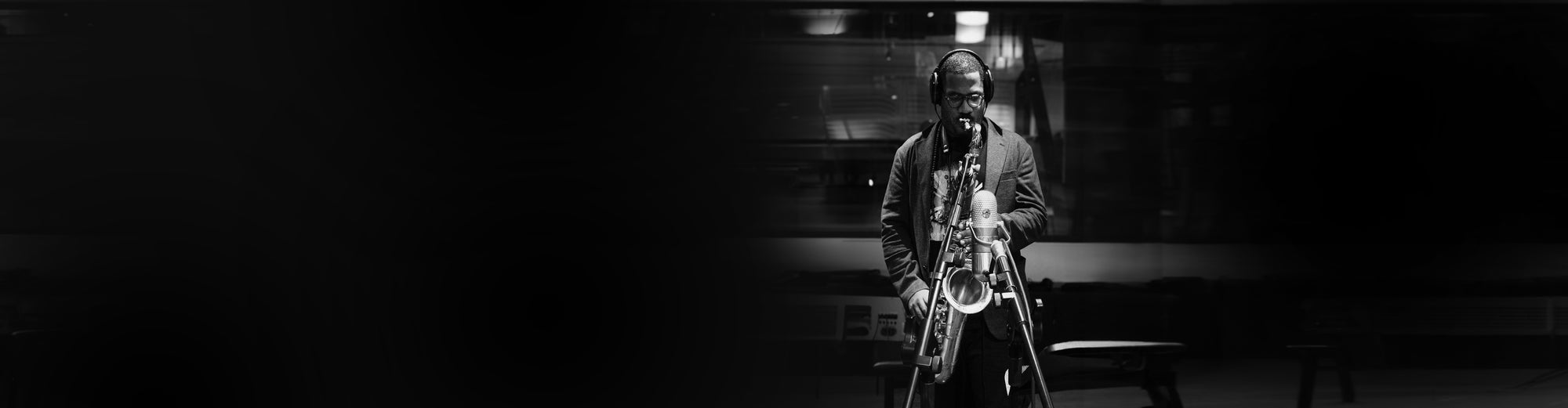 James Brandon Lewis playing a saxophone in a dark room with a spotlight